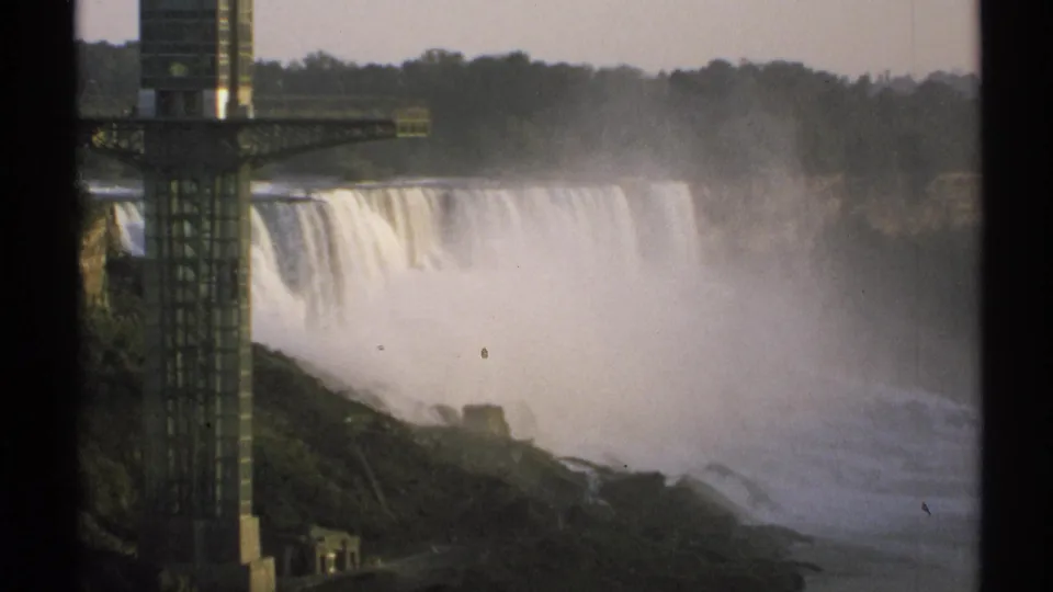 1971 8mm New York view of Niagara Falls with a tall observation tower in the foreground and mist rising over the gorge.