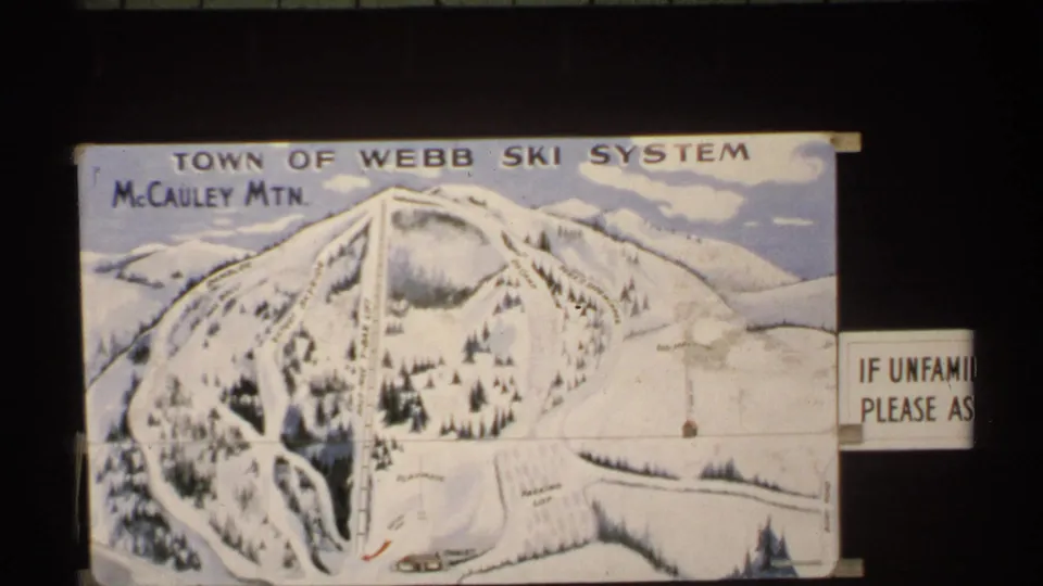 1971 New York frame showing a Town of Webb Ski System map labeled McCauley Mtn beneath a dark-framed view of trees and houses.