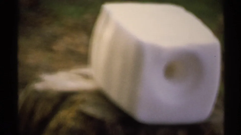 Soft 8mm close-up of an unidentified white box-like discarded object outdoors in New York, filmed in 1971.