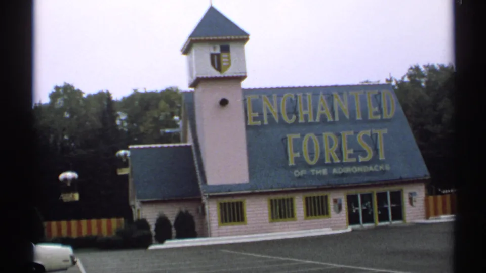 1971 New York frame with the Enchanted Forest exterior, bold yellow roof lettering, tower and glass entrance doors.