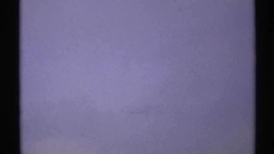 Overexposed 8mm transition frame, likely sky or a camera adjustment, with blue-gray color fading and dark frame borders.