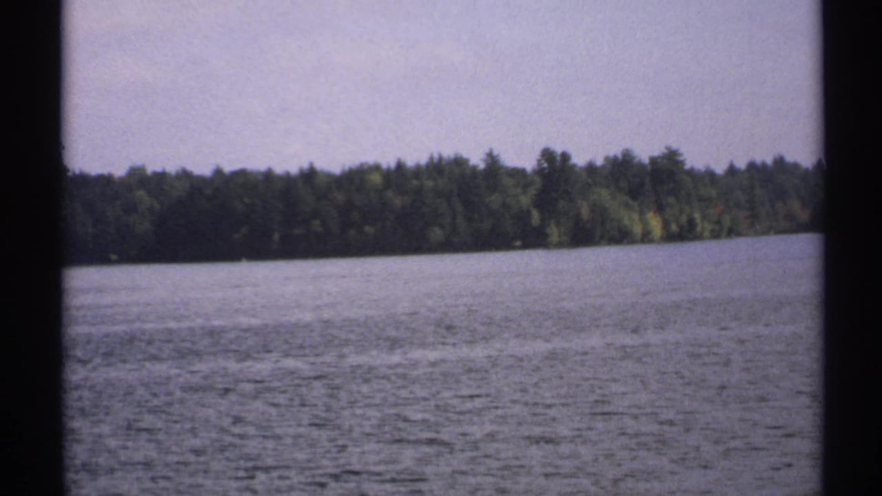 Wide lake water with a wooded shoreline in the distance.