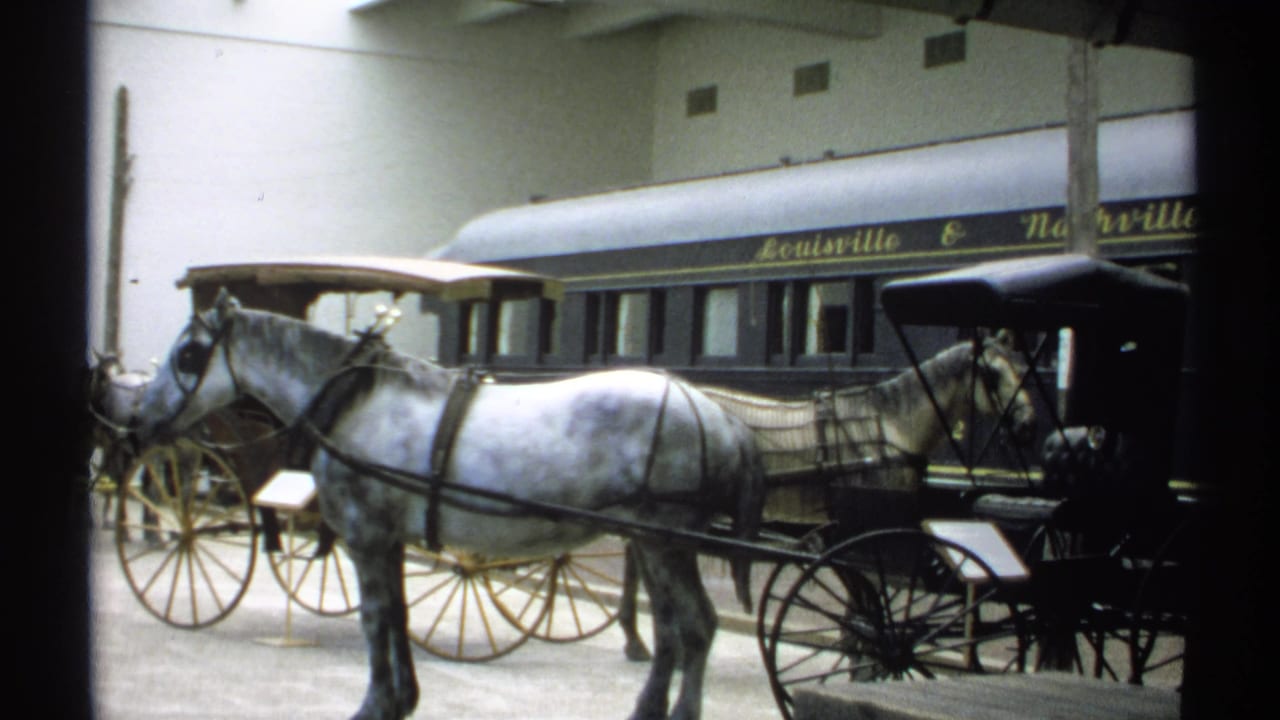 A 1971 indoor exhibit view shows a white horse harnessed to a buggy, with the Louisville & Nashville rail car behind.