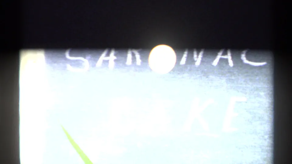 Bright moon over a partial hand-painted Saranac Lake sign in 1971 New York home-movie footage.