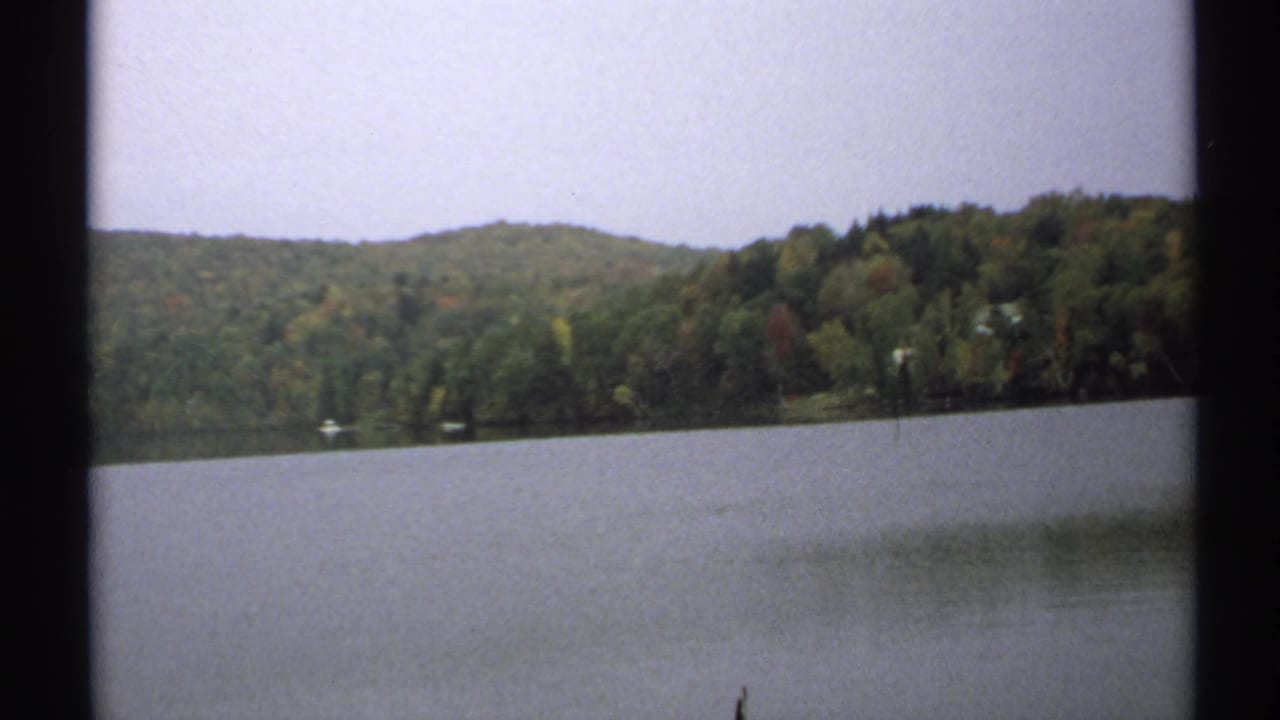 Wide lake view with wooded hills, distant shoreline, and dark 8mm borders.