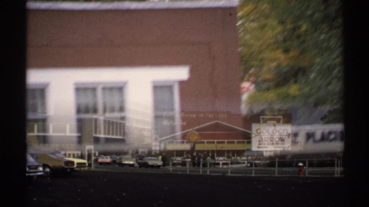 Commercial street with Golden Arrow signage, parked cars, and a Shell sign.