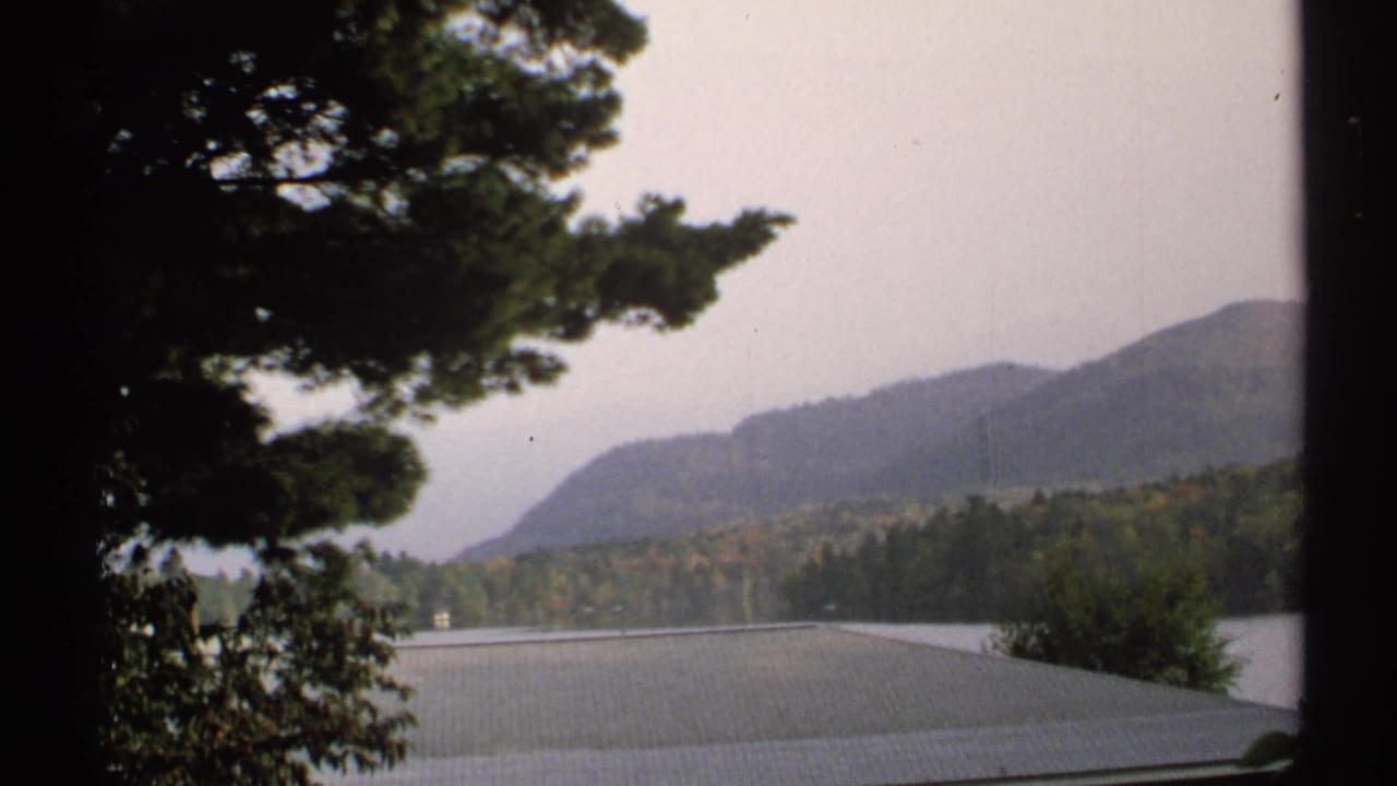 1971 New York 8mm view across water toward forested hills, with trees blocking part of the frame.