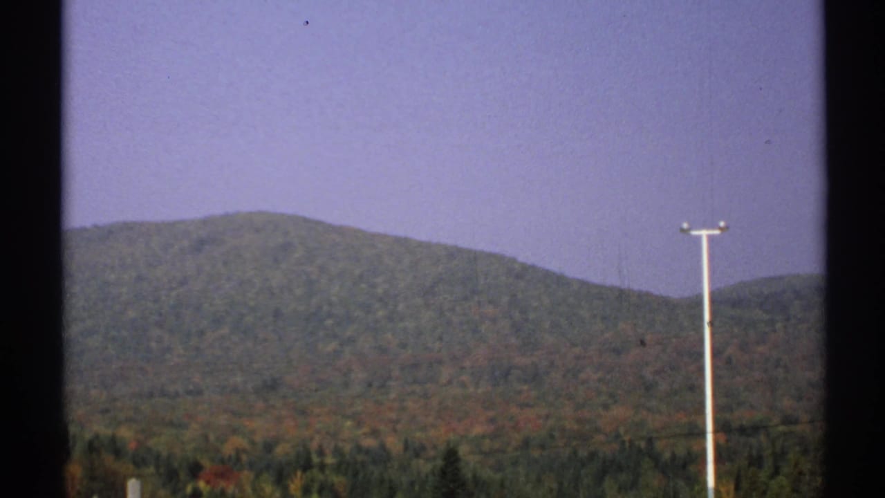 Autumn hills with a utility pole at right and dark vertical frame edges.