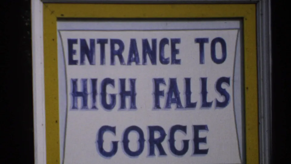 1971 New York 8mm close-up showing the High Falls Gorge sign centered within a yellow-bordered frame.