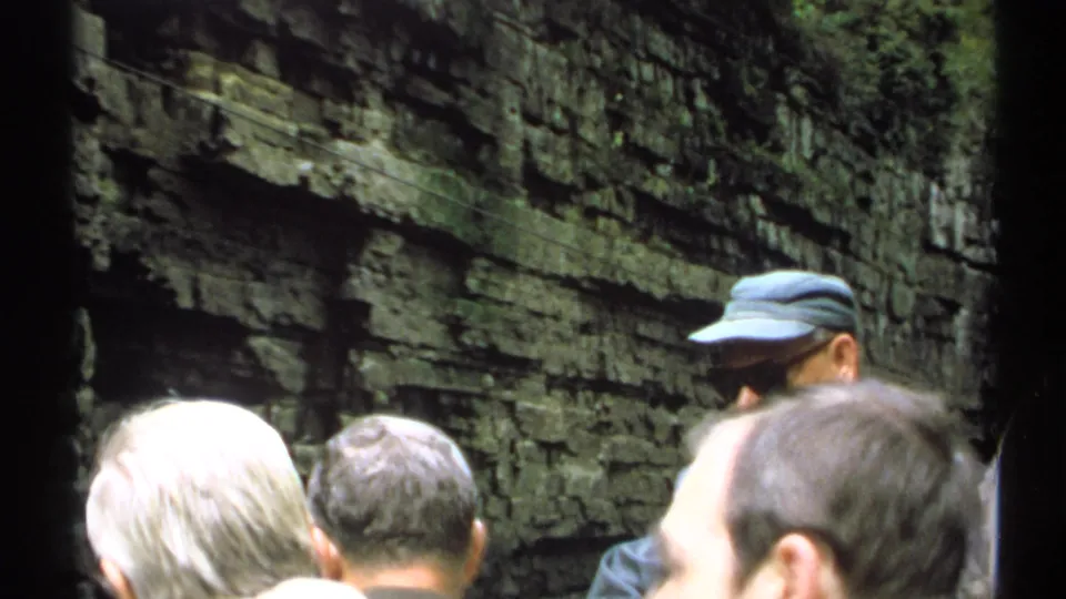 Adult visitors stand close together in the New York gorge, seen against rough layered stone walls in 1971 8mm footage.