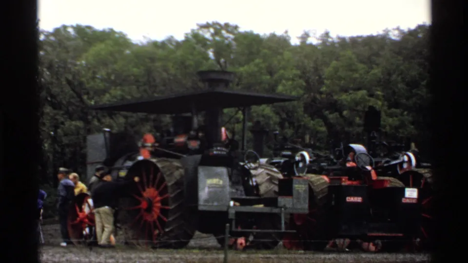 A large steam traction engine and nearby equipment sit among visitors at the 1971 Rollag, Minnesota rural agricultural fair.