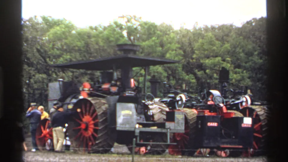 Outdoor 1971 Rollag fair view of black and red steam traction engines, including machinery with visible Case markings.