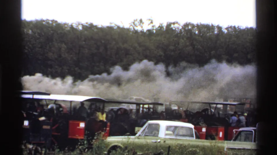 1971 Rollag, Minnesota 8mm view of steam engines producing smoke as spectators stand near a parked pickup.