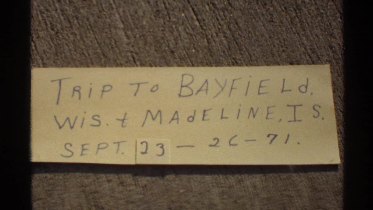 Handwritten 1971 trip note referencing Bayfield, Wisconsin and Madeline Island on a yellow slip of paper.