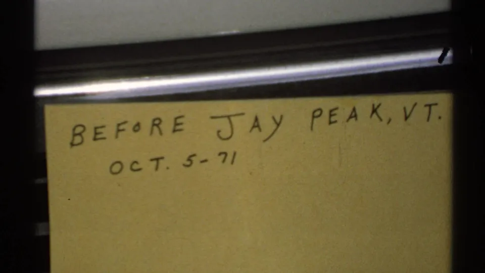 Close-up 8mm frame of a yellow handwritten note card dated Oct. 5, 1971, referring to before Jay Peak, Vermont.