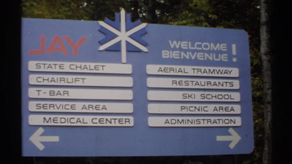 Closer 1971 Vermont 8mm view of the Jay State Chalet sign with bilingual welcome text and directional arrows.