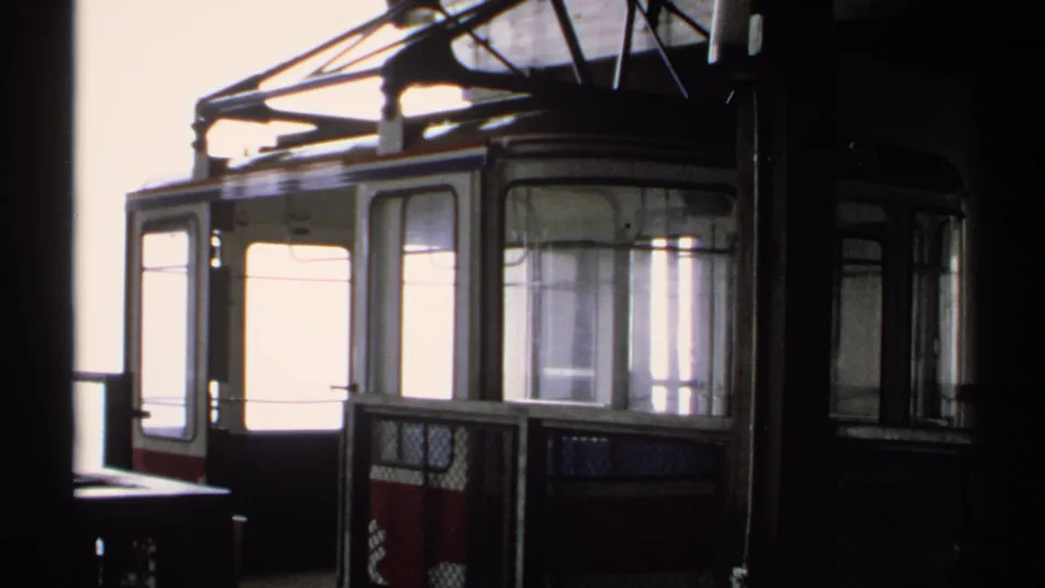 1971 Vermont frame with the cable car cabin partly backlit inside a mountain station, showing windows, doors, and roof hardware.