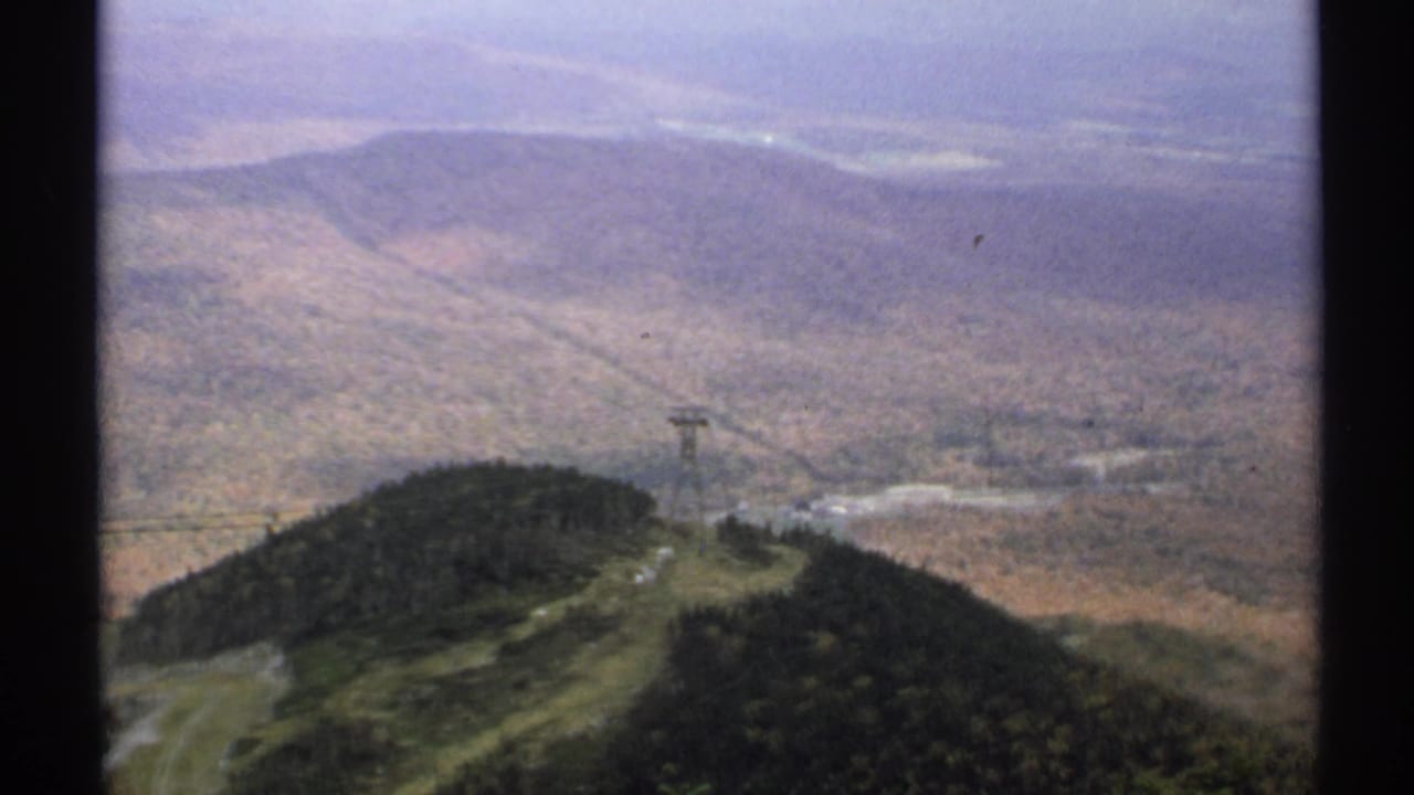 The tramway tower and ridge remain centered with muted hills in the background.