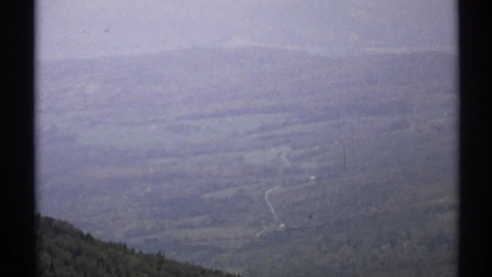 1971 Vermont 8mm frame with a faded, hazy view of valley terrain, ridges, and projected-film borders.