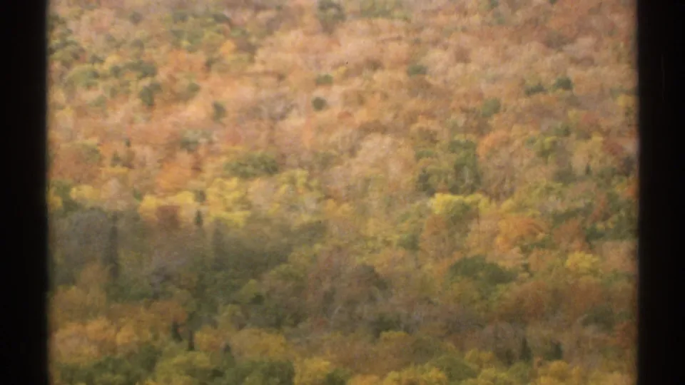 1971 Vermont 8mm frame with motion-blurred fall trees viewed from the ski lift.