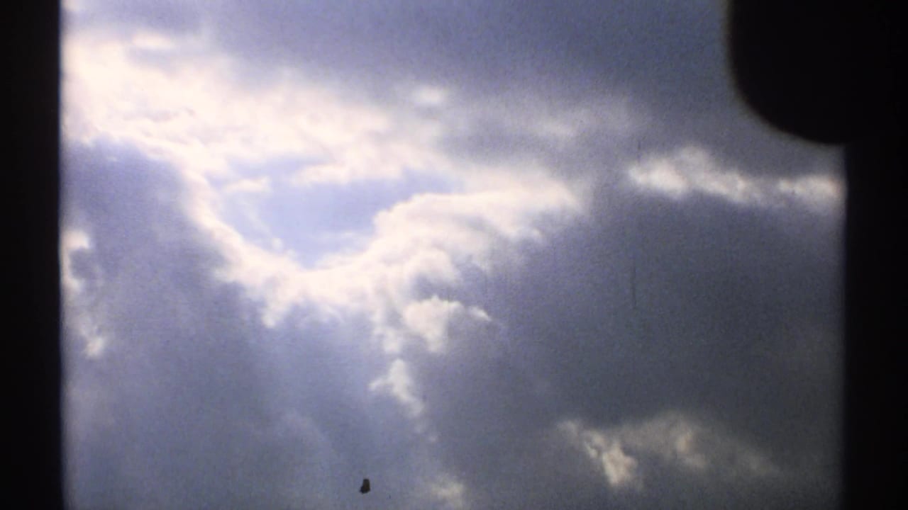 Dark clouds with bright sunlight breaking through near the upper center of the sky.