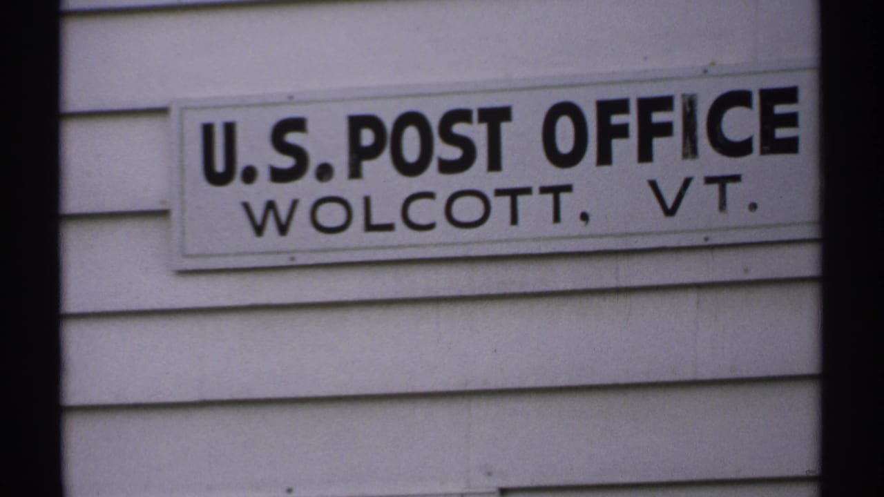 U.S. Post Office Wolcott, VT sign centered on a white clapboard exterior.