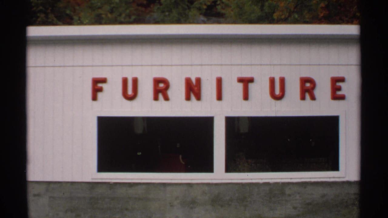 Second view of the Furniture sign on a white storefront, partly divided by film frame edges.