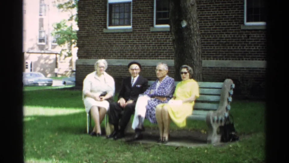 At the end of the clip, four older adults remain seated on the bench in the 1971 Wisconsin outdoor home-movie scene.