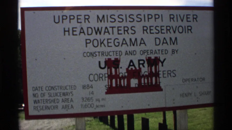 1971 Wisconsin 8mm frame showing a U.S. Army Corps of Engineers sign for Upper Mississippi River Headwaters Reservoir and Pokegama Dam.