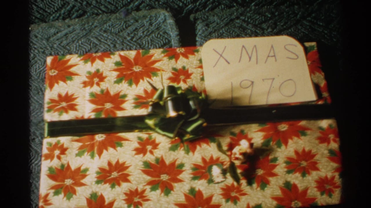Wrapped Christmas gift with green bow and handwritten tag reading XMAS 1970.