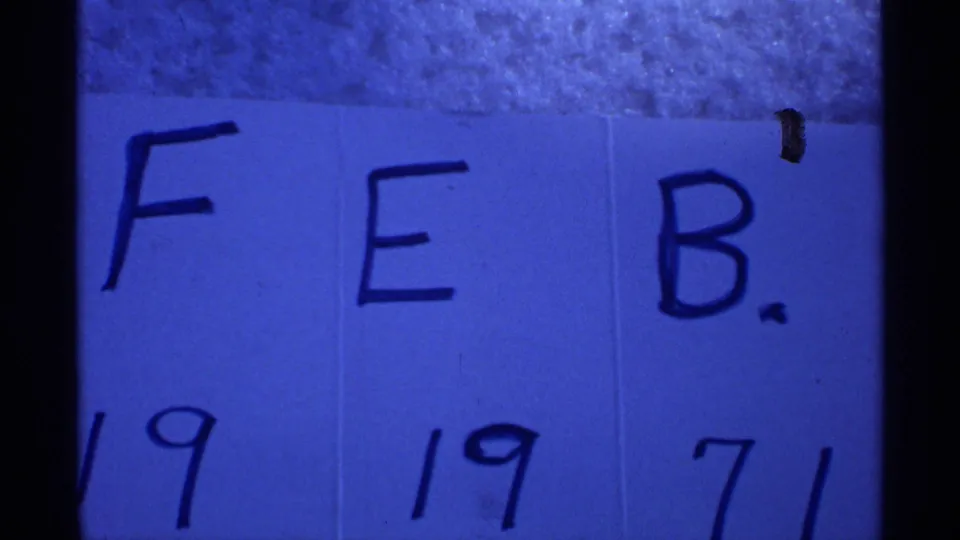 Blue-tinted 8mm frame showing a handwritten FEB. 19 1971 card, supporting the clip's Wisconsin 1971 metadata.