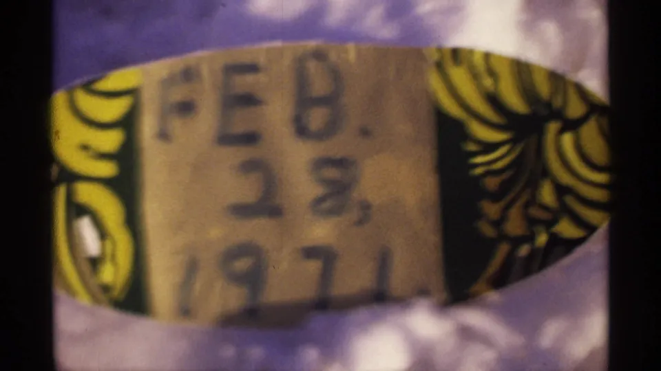 Close 8mm frame of a handwritten label reading FEB. 28, 1971, partly soft and framed by dark film edges.