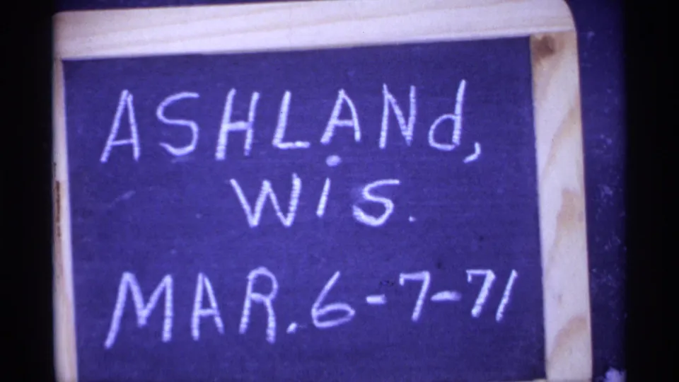 Wood-framed handwritten board reading Ashland, Wis. Mar. 6-7-71 in saturated 8mm color.