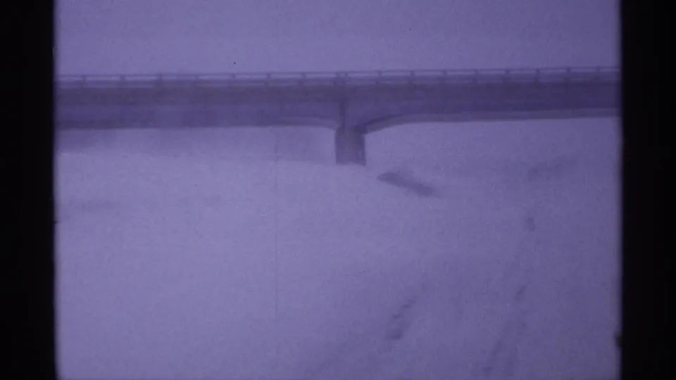 A faint bridge or overpass appears through blizzard conditions in 1971 Wisconsin 8mm footage.
