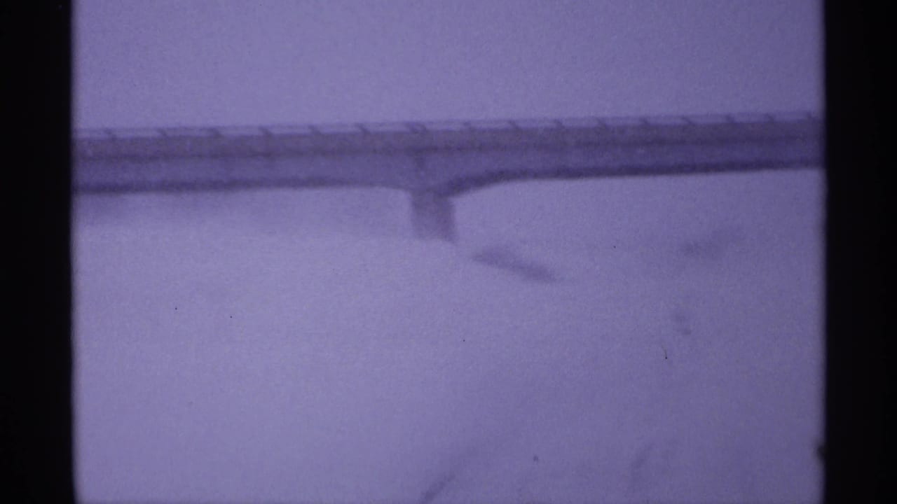 Snowy overpass seen through haze with dark film borders.