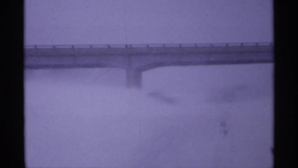 A distant overpass cuts across a pale snowy Wisconsin landscape, softened by 8mm grain and winter haze.