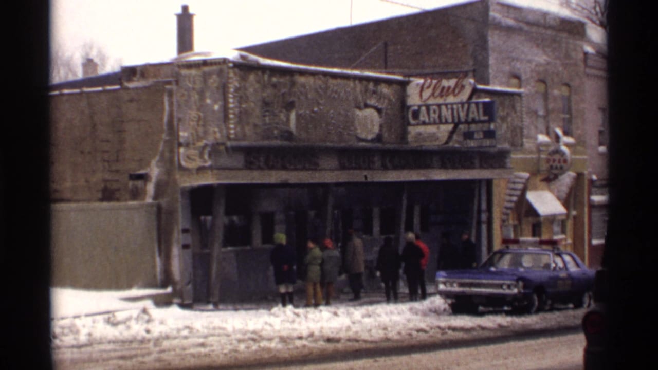 Club Carnival exterior with people near the entrance and a blue police car at the curb.
