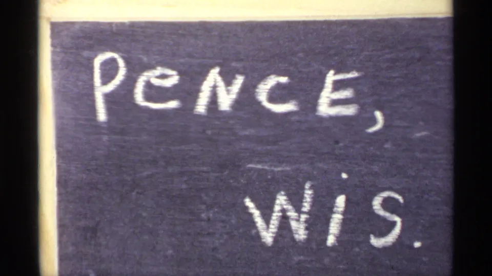 Handwritten 8mm location slate reading Pence, Wis., supporting the Wisconsin location for the surrounding winter footage.
