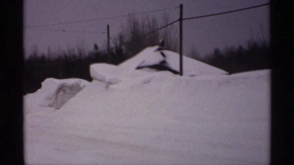 Rural Wisconsin winter roadside in 1971 with heavy snow piled high near utility poles and leafless trees.
