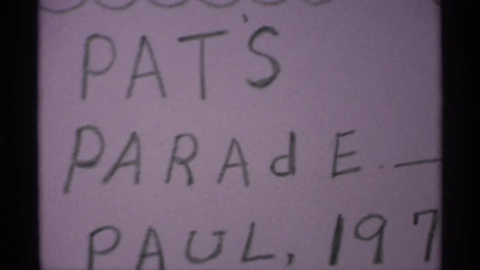 Soft 8mm close-up of the Pat's Parade handwritten title card with partial Paul, 1971 wording.