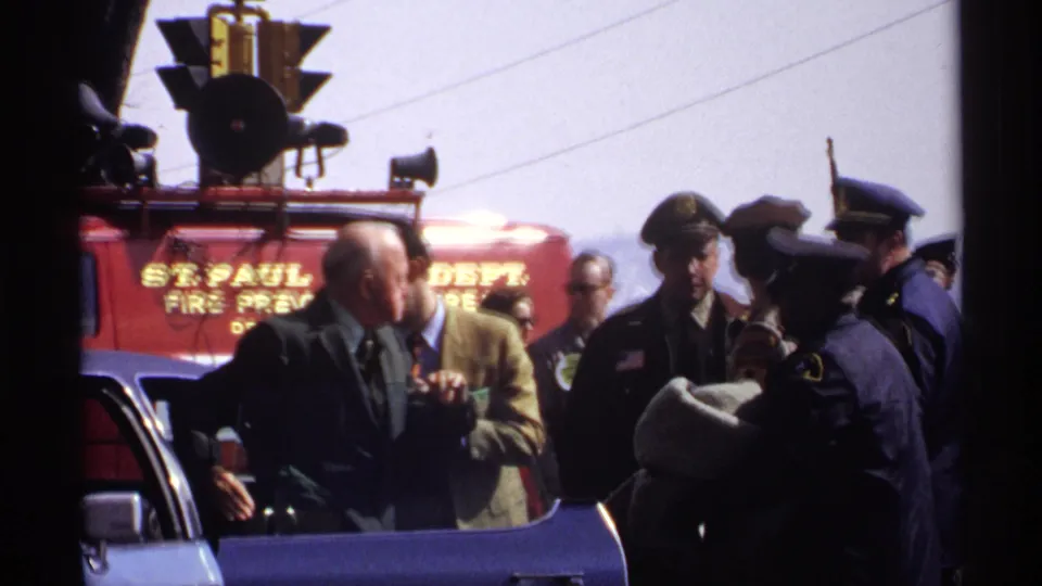 1971 Wisconsin street scene with a red fire truck marked for a fire prevention unit and several men gathered in front.
