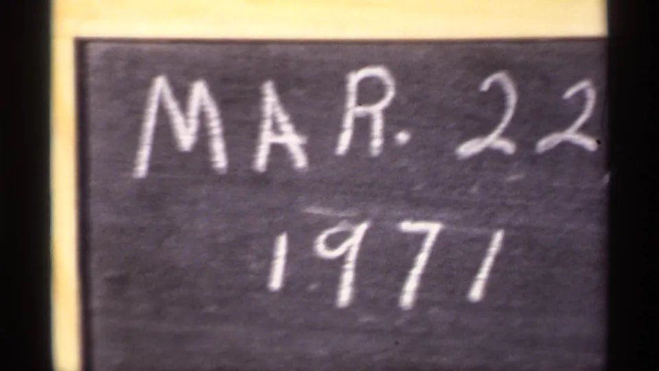 Soft-focus 8mm frame of the handwritten date card, with MAR. 22 and 1971 still visible inside a yellow border.