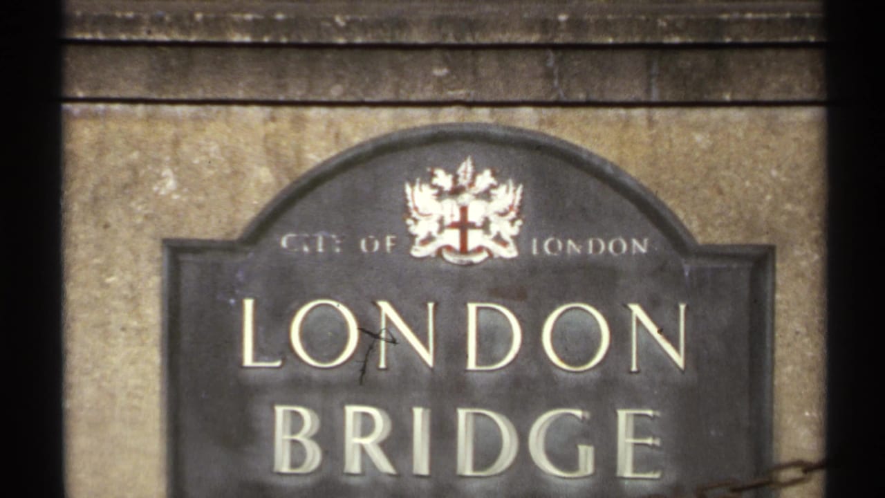 Close view of a London Bridge sign with the City of London crest on a stone wall.