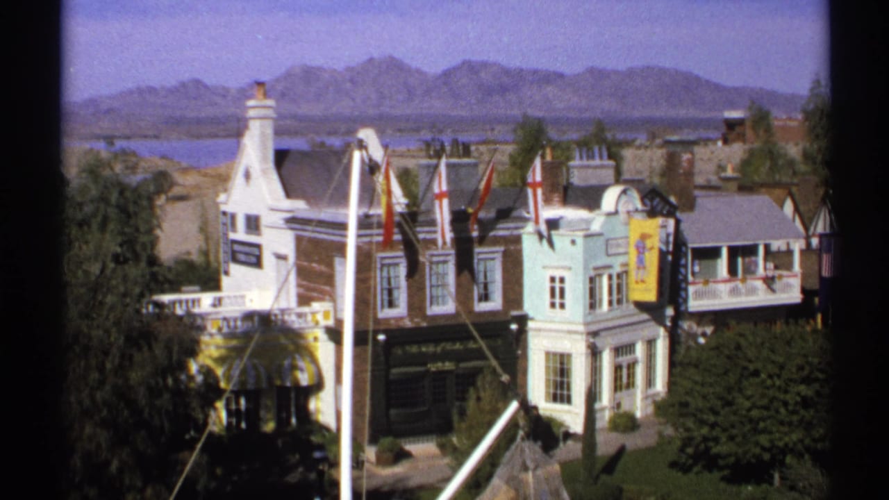 Colorful miniature buildings with flags and a distant mountain backdrop.