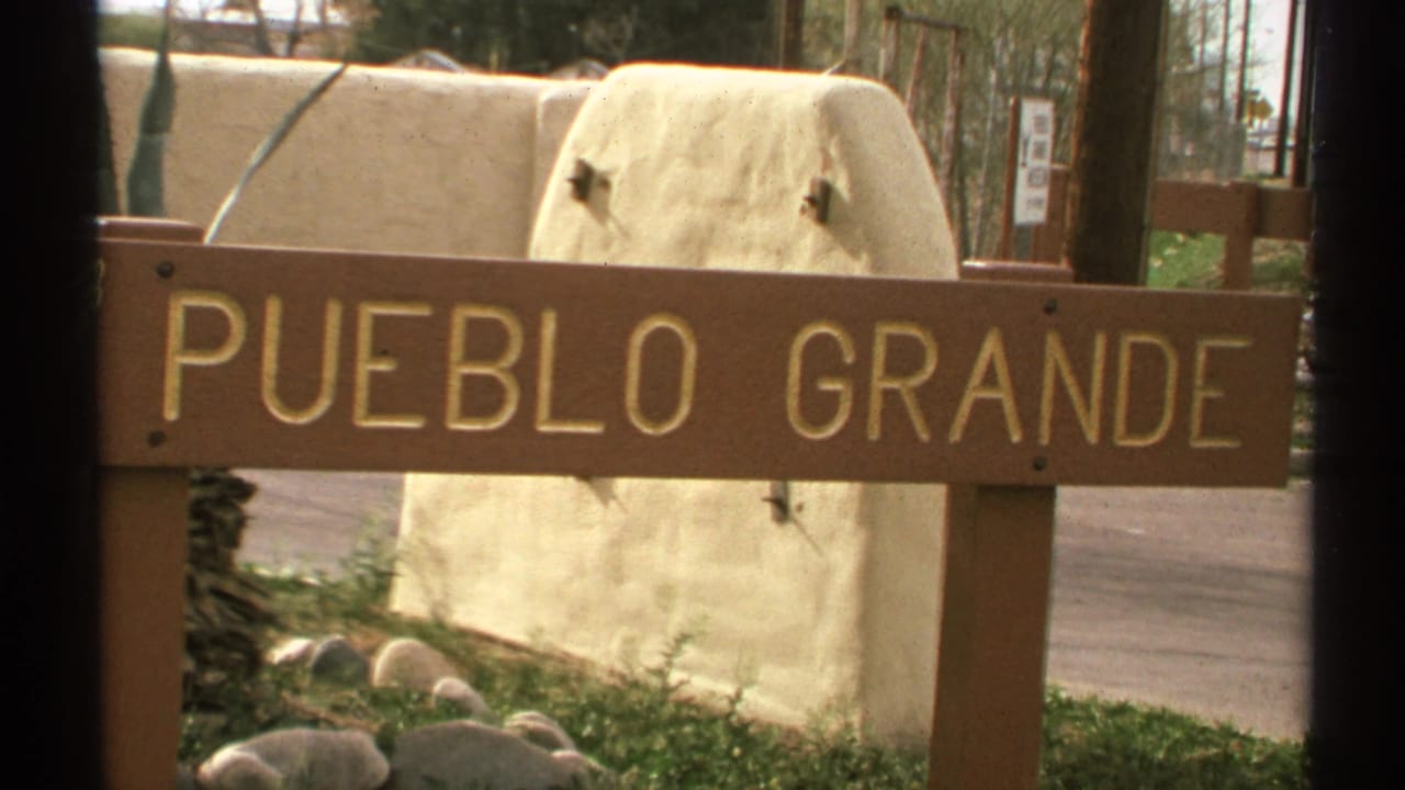 Pueblo Grande sign with large gold letters, partially framed by dark vertical edges.
