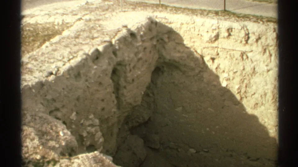 1972 Arizona 8mm frame showing the trench from a similar angle, with jagged pale soil, loose earth, and a darker shadowed hollow.