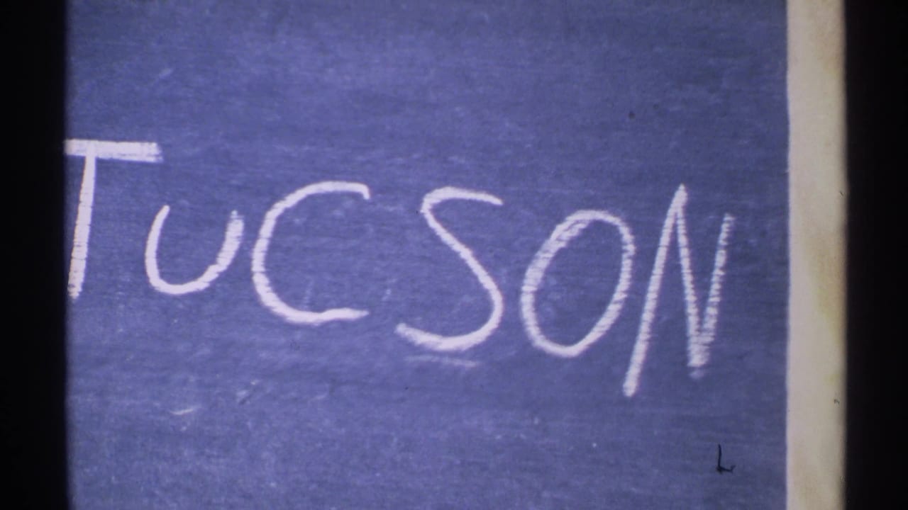 Second view of the blue Tucson title card with chalk lettering.