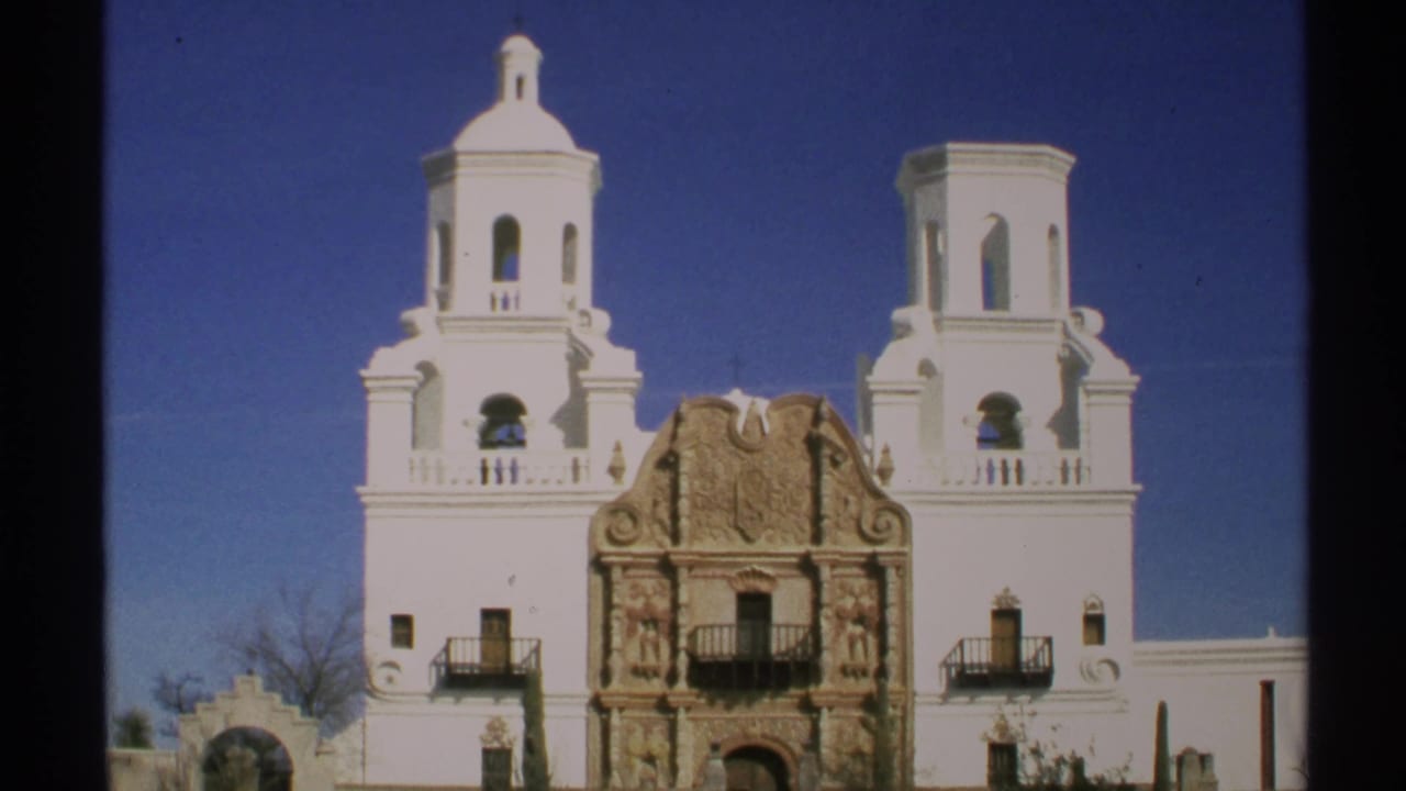 Twin bell towers and ornate church facade framed against a clear sky.