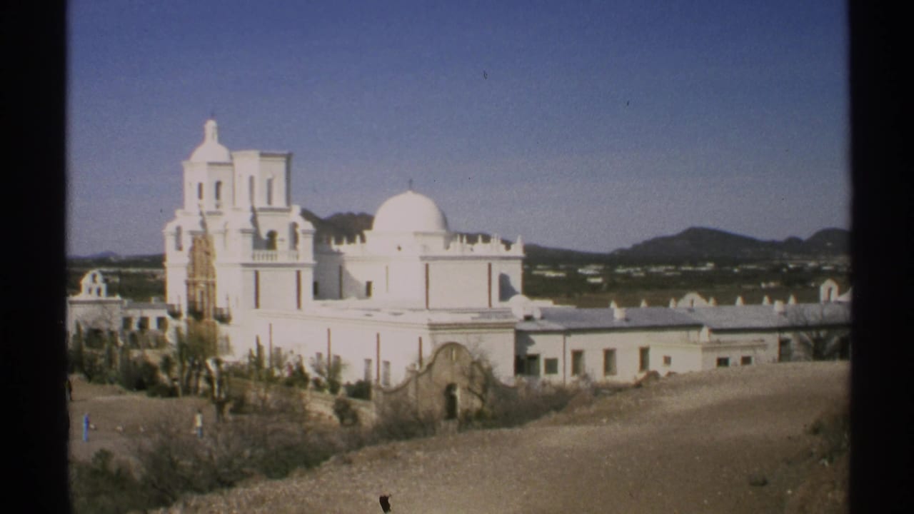 Similar wide view of the white church complex with mountains in the background.