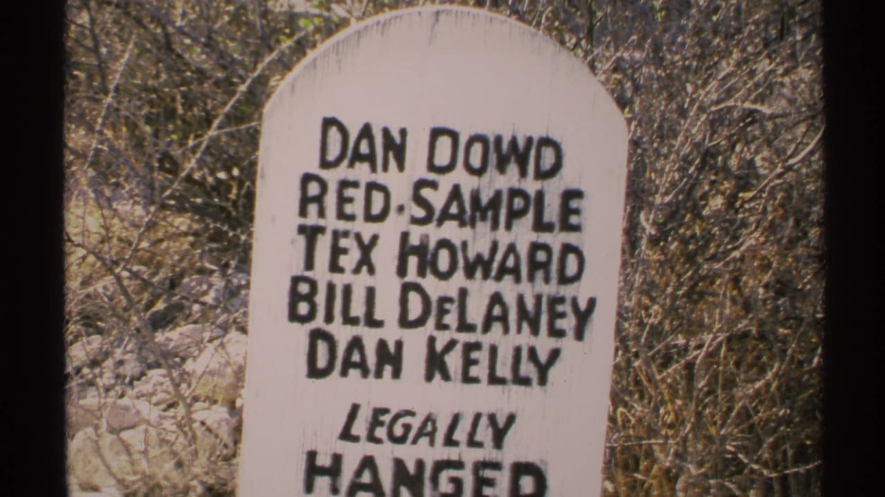 Close view of a white painted marker with black names and dry brush behind it.